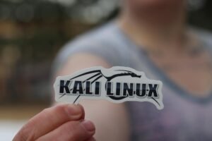 a hand holding kali linux sticker in close up photography